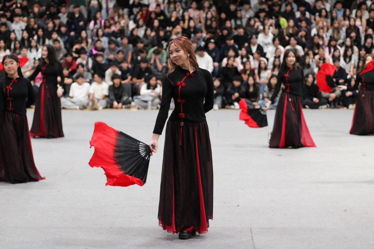 Senior Olivia Nguyen performs a traditional Chinese fan dance with fellow Chinese Club members during the annual IFF assembly on Friday, Feb. 6.
