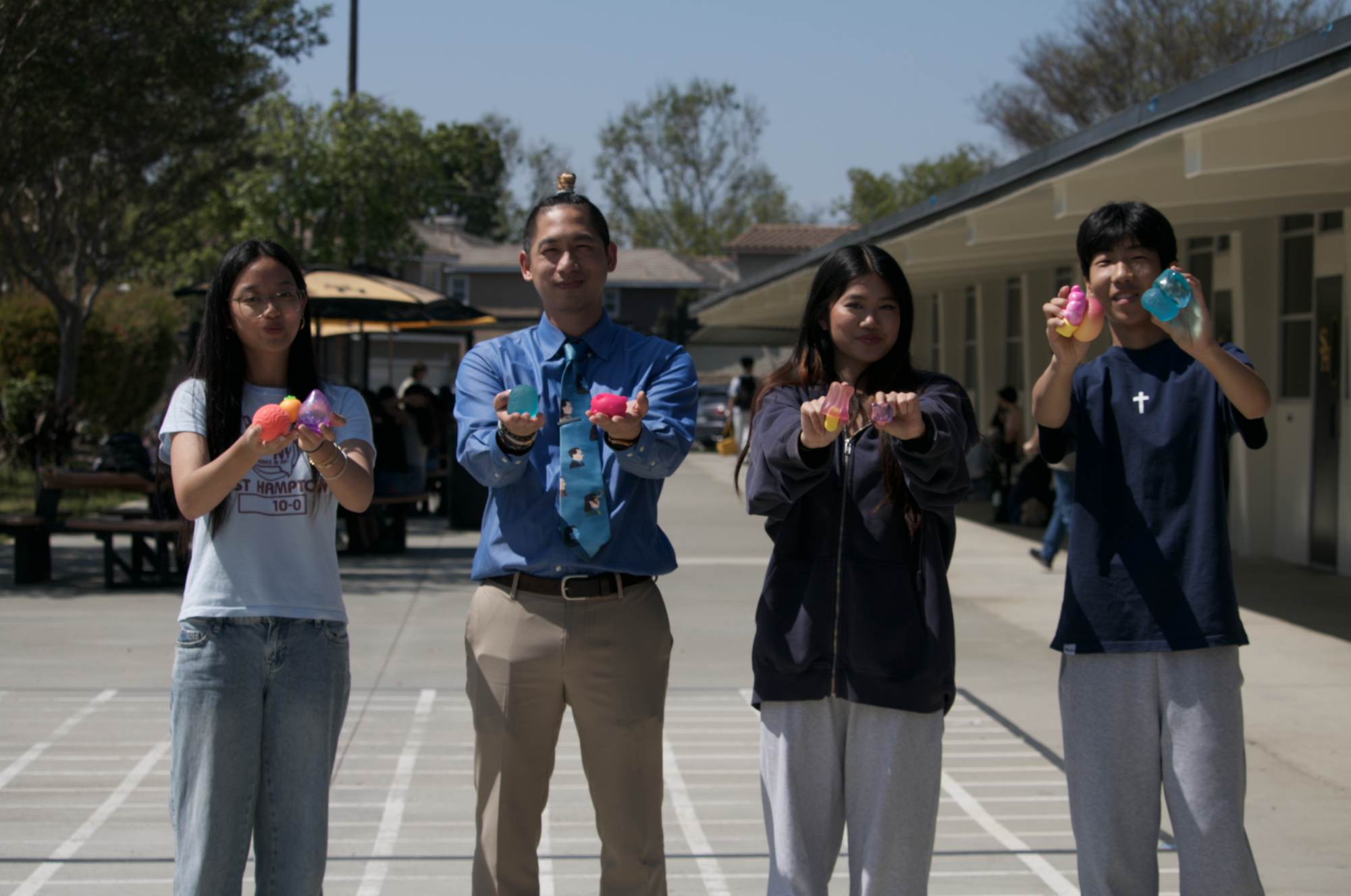Sophomore Khloe Fung (left), science teacher Alexander Hua, junior Abbie Nguyen and freshman Brandon Kim show off their NeeDoh collection in front of Hua’s classroom on Tuesday, March 24. 