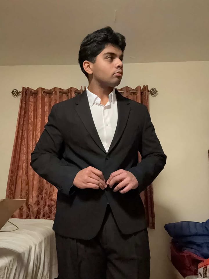 Senior Rudra Kharwa fixes the button on his prom suit jacket in his home on Tuesday, April 7.