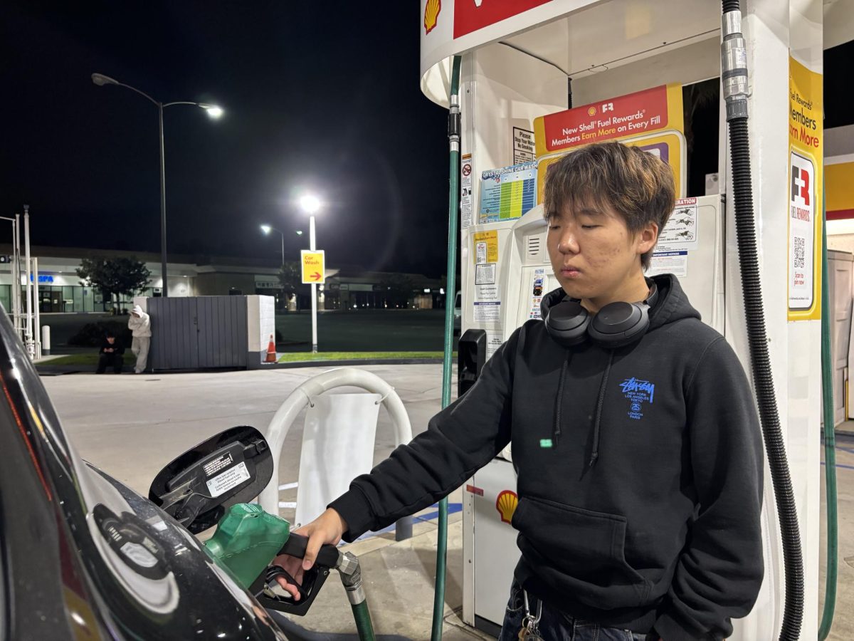 Senior Ian Chung fills up his car with diesel at the Shell gas station in Buena Park on Saturday, April 18, at 12:40 a.m.
