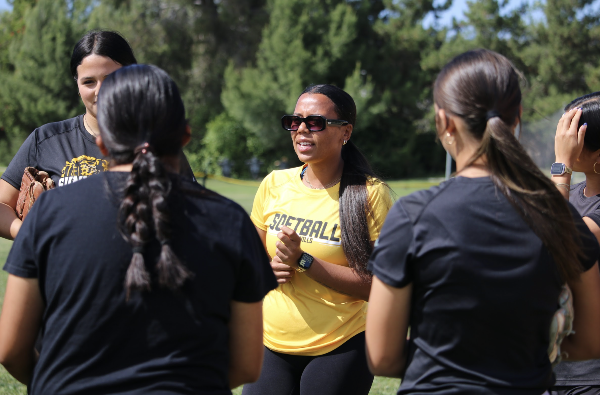 New head softball coach Alia Marquez consults with her team on Friday, April 24, on the Sunny Hills field. 