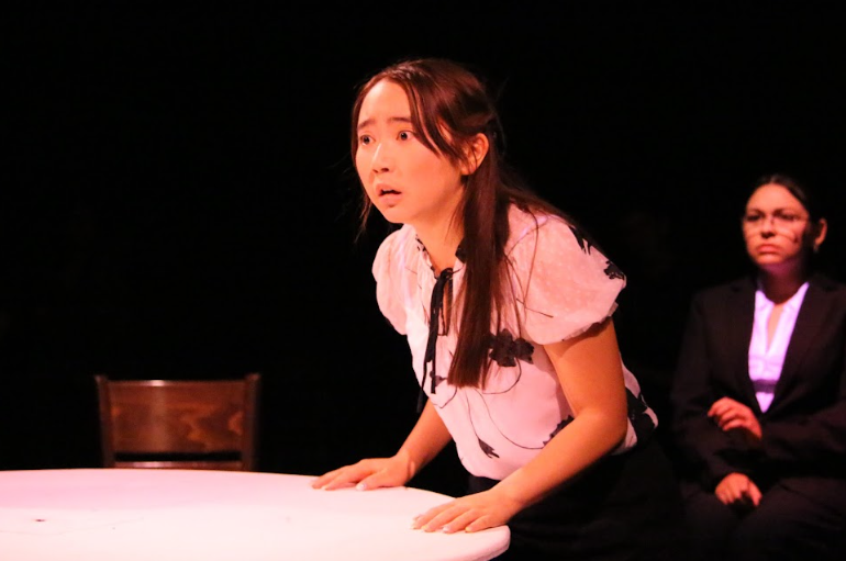 Senior Mia Cho, who plays Juror #5, frantically dissects evidence from the trial during the first performance of “12 Angry Jurors” on Monday, April 27.